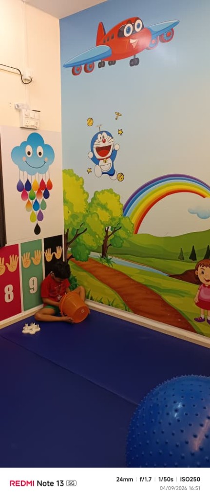 Child engaged in play-based therapy in a mural-decorated therapy room