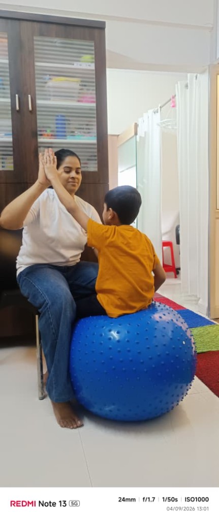 Therapist and child celebrating progress during a therapy session